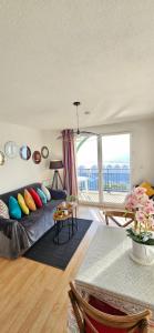 a living room with a couch with colorful pillows at SUNSET 3o2 in Cayeux-sur-Mer