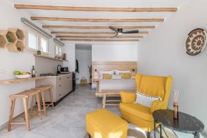 a kitchen and living room with yellow chairs and a bed at My Honey Bee in Kástron