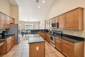 a large kitchen with wooden cabinets and black counter tops at Gilbert Getaway in Gilbert