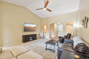 a living room with a couch and a flat screen tv at Gilbert Getaway in Gilbert