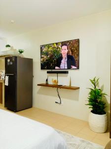 ドゥマゲテにあるNorman Condominium Unit Rental Sea Viewの冷蔵庫付きの客室の壁にテレビが備わります。