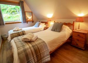 ein Schlafzimmer mit zwei Betten und einem Fenster in der Unterkunft Lochinver Holiday Lodges & Cottages in Lochinver