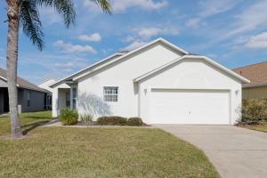 a white house with a white garage at Quiet Getaway Nr Golf & Posner Park with Pool in Davenport