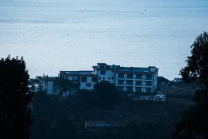 un gran edificio blanco frente al océano en Essencia Kivu Hotel, en Shangugu