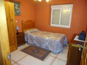 a small bedroom with a bed and a window at La Coruxa in Los Cabos