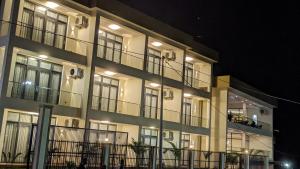 un gran edificio blanco con ventanas por la noche en Essencia Kivu Hotel, en Shangugu
