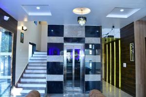 a lobby with a staircase with a glass elevator at Yashdeep Palace in Tapukrah