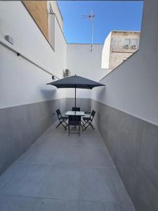 メリダにあるApartamento Martina 2のテーブル、椅子、パラソルが備わります。