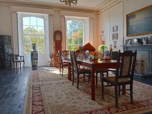 Un comedor con una mesa y sillas y un reloj. en Woodlands, Teignmouth, en Teignmouth