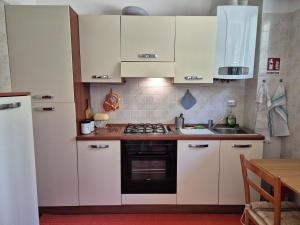a kitchen with white cabinets and a stove top oven at Appartamento La Casetta in Varazze +7 photos