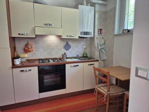 a kitchen with white cabinets and a stove and a table at Appartamento La Casetta in Varazze