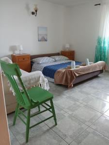 a bedroom with a green chair and a bed at Apartments Sova in Postira