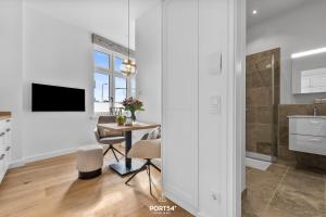 a kitchen and dining room with a table and a television at Ferienwohnung Kleine Welle Westerland auf Sylt in Westerland (Sylt)