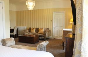 a hotel room with a bed and a couch at The Belsfield Hotel in Bowness-on-Windermere