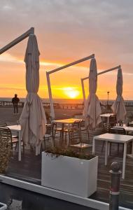 a sunset on the beach with tables and umbrellas at La Torretta Sul Porto - Parcheggio gratuito in Livorno