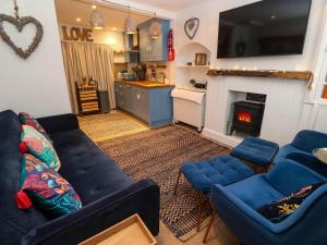 a living room with blue couches and a fireplace at Seahorse Cottage in St Ives