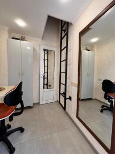une pièce avec un miroir, deux chaises et une échelle dans l'établissement Studio33, à Erevan