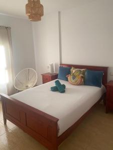 a bedroom with a large bed with blue pillows at Light House in Corralejo +6 photos