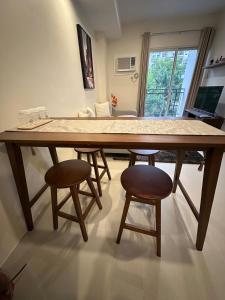a large wooden table with two stools in a room at Condo in Davao City in Davao City