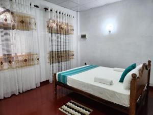um quarto com uma cama e paredes e cortinas brancas em Mango Villa Hiriketiya em Hiriketiya