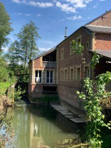 an old brick building next to a river at La Laiterie 