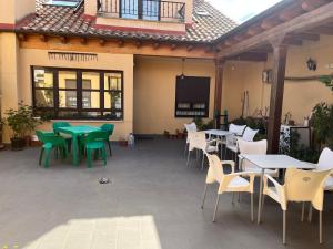a patio with tables and chairs in a building at Hotel Rural El Puente in Mansilla de las Mulas