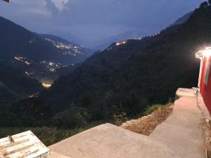 a view of a mountain at night from a bench at ᴛʀɪꜱʜᴀᴋᴛɪ ᴀᴜʀᴀ in Barmoāri +4 photos