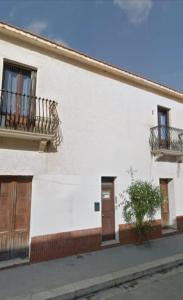 a white building with two balconies and a door at Casa Platamone 2 in San Vito lo Capo