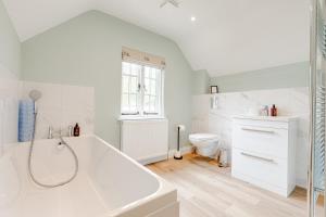 une salle de bain blanche avec une baignoire et des toilettes dans l'établissement Old Town Cottage, à Nuneham Courtenay 35 autres photos