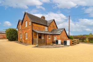 une grande maison en briques avec deux réfrigérateurs devant dans l'établissement Old Town Cottage, à Nuneham Courtenay