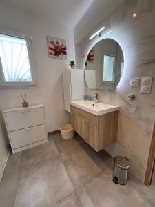a bathroom with a sink and a mirror at T2 aile de villa et Spa-jacuzzi privé et illimité et plateau d'acceuil offert! in Camps-la-Source
