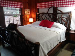 a bedroom with a wooden bed with a red pillow at The Manor at Becks Lake in Rockmart