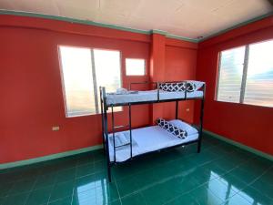 Lapu Lapu CityHostel Home in Lapu-Lapu City的带两张双层床和红色墙壁的客房