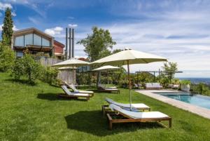 a group of chairs and umbrellas next to a pool at Casale Caldesòra AgriBoutique BnB the Charme in Vittorio Veneto