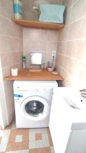 a bathroom with a washing machine and a sink at Maison entière Guilvinec in Le Guilvinec