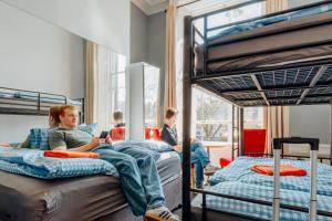 a group of people sitting on bunk beds in a room at Eden Quay Guesthouse Private Rooms in Dublin