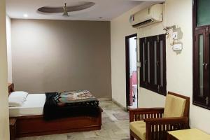 a bedroom with a bed and a chair and a window at Hotel High Pointe in Jodhpur +9 photos