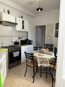 a kitchen with a table with chairs and a stove at Dar Yassine in Sahline