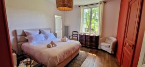 a bedroom with a bed with shoes on it at Le Domaine Lieu Bill, Normandie in Blonville-sur-Mer