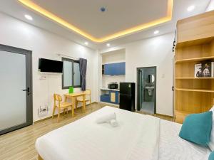 a bedroom with a bed and a table and a kitchen at Urbanest Saigon in Ho Chi Minh City