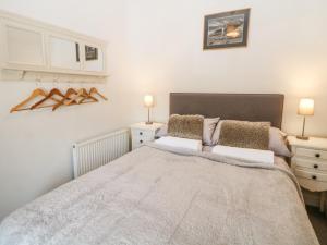 a bedroom with a large bed and two night stands at Bank Cottage in Bradwell