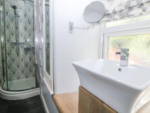 a bathroom with a white sink and a shower at Bank Cottage in Bradwell +25 photos