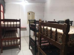 a room with two bunk beds and a room with a table at Suíte Albergue em Casa de Excursão in Cabo Frio +7 photos