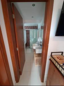 Residência em condom, 1 ou 2 suítes, vista para o mar, Praia do Curral, Ilhabela في إلهابيلا: حمام مزود بحوض ومِرآة