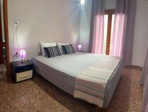 a bedroom with a large bed with two lamps on it at Palm Memories in Ierissos