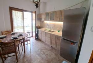 a kitchen with a table and a stainless steel refrigerator at Palm Memories in Ierissos