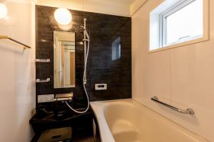 a bathroom with a bath tub and a sink at The SMILE in Sapporo +37 photos