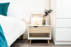 a bedside table with a lamp on it next to a bed at Central Apartment - Sheffield in Sheffield