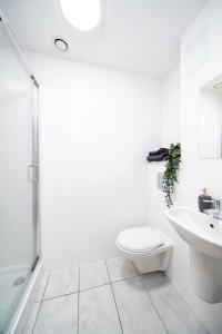 a white bathroom with a toilet and a sink at Central Apartment - Sheffield in Sheffield +11 photos