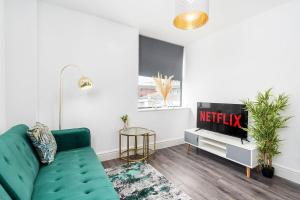 a living room with a green couch and a tv at Central Apartment - Sheffield in Sheffield